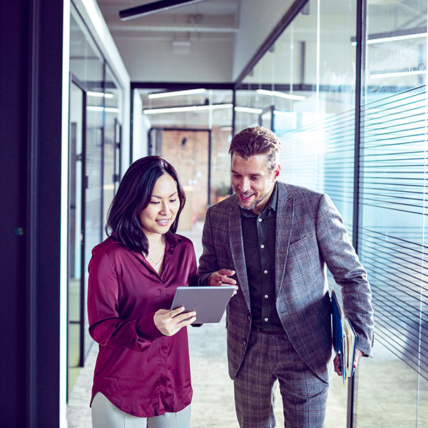 Man and woman looking at tablet in hallway