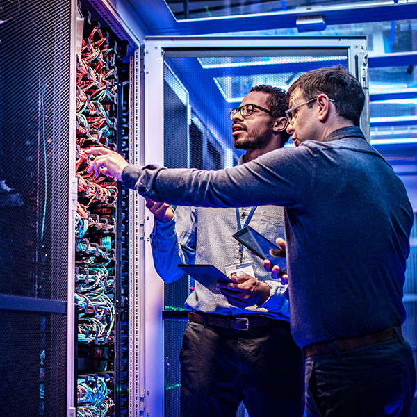 Data center male technicians inspecting servers