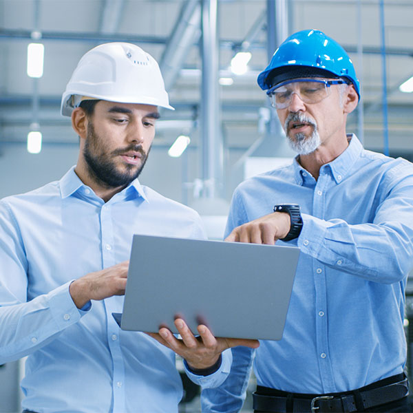 Men walking through facility with laptop