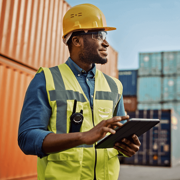 Construction worker holding tablet in supply yard
