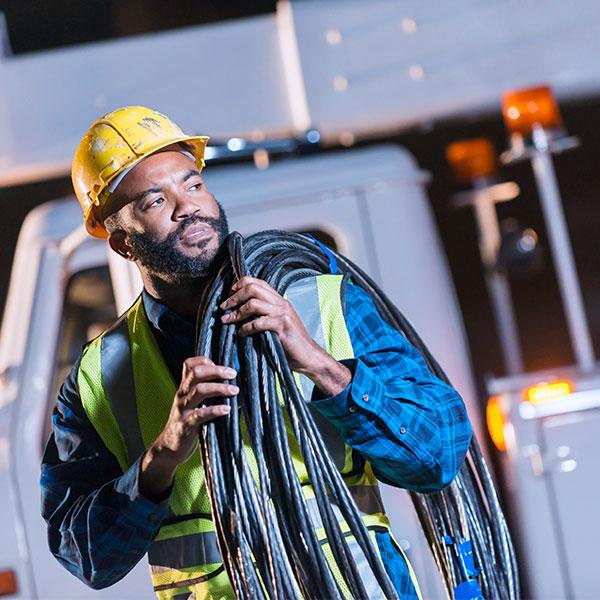 Industrial worker carrying utility cables man averted gaze