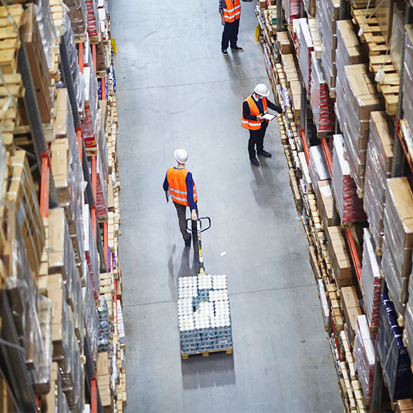 Aerial view of warehouse worker pulling dolley