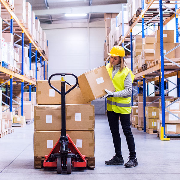 Woman loading boxes on forklift in warehouse averted gaze