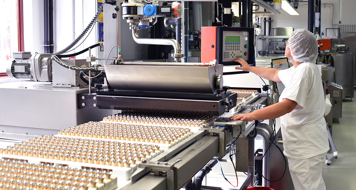 Worker at food product line in factory