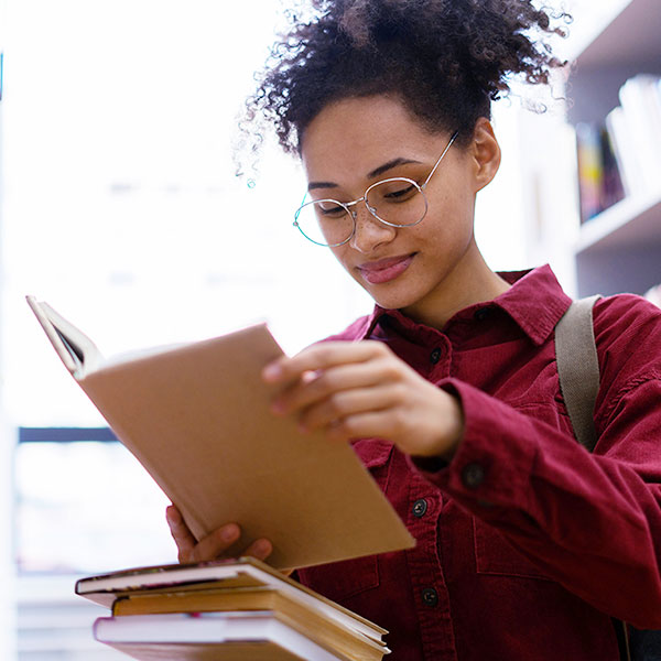Woman reading book in library