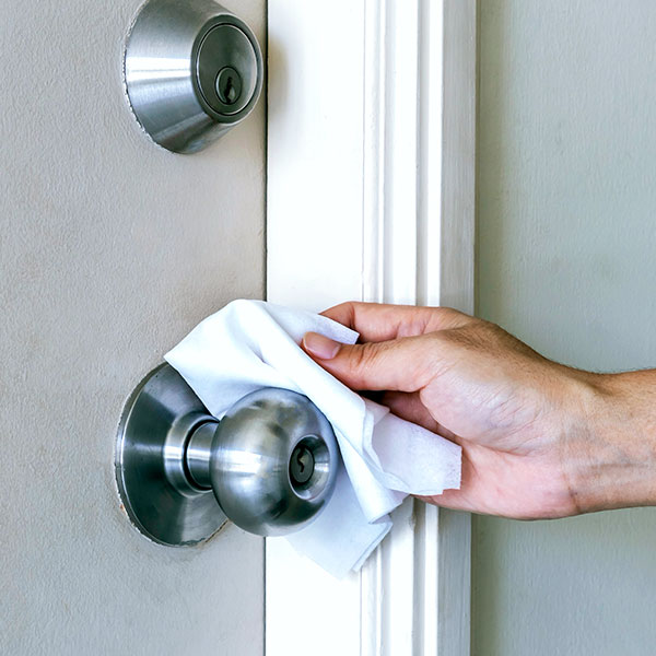 Closeup of person sanitizing a doorknob