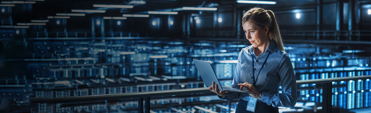 Woman in large data center with laptop