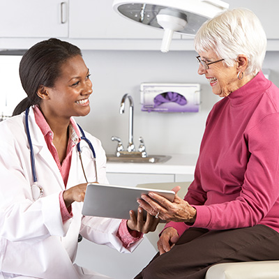 Doctor showing tablet to elderly patient