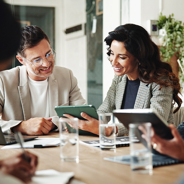 Coworkers looking at tablet in office