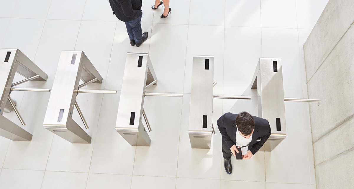 Man walking through access control turnstiles aerial
