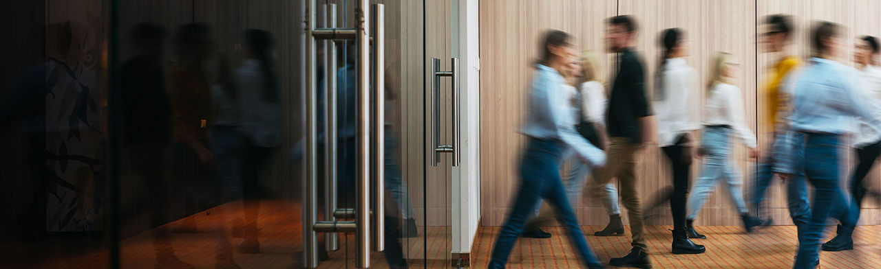 Blurred people walking through building lobby