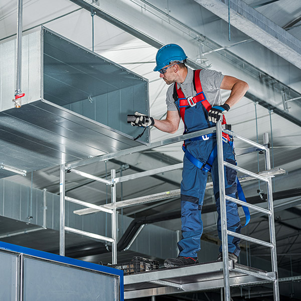 Worker wearing fall protection safety gear.