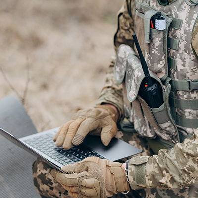 Soldier using laptop outdoors