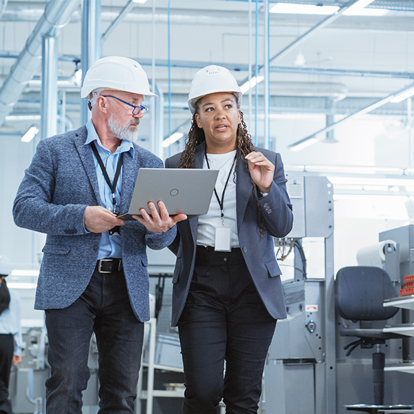 Engineers with laptop in industrial space