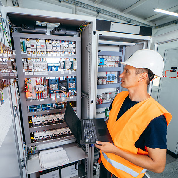 Engineer working on industrial electrical panel board building.