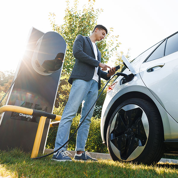 Man charging electric vehicle