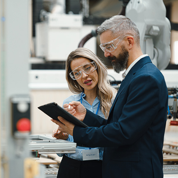 Facility managers with safety glasses viewing tablet