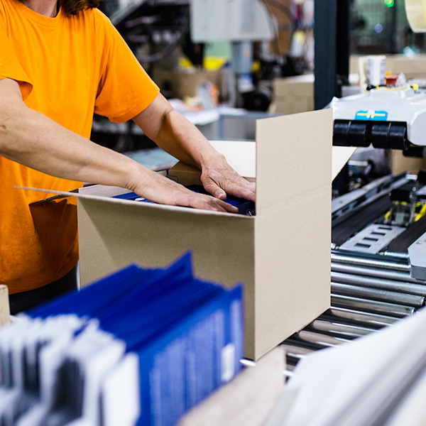 Worker packaging box in assembly line