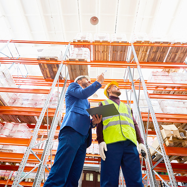 Workers in warehouse with clipboard