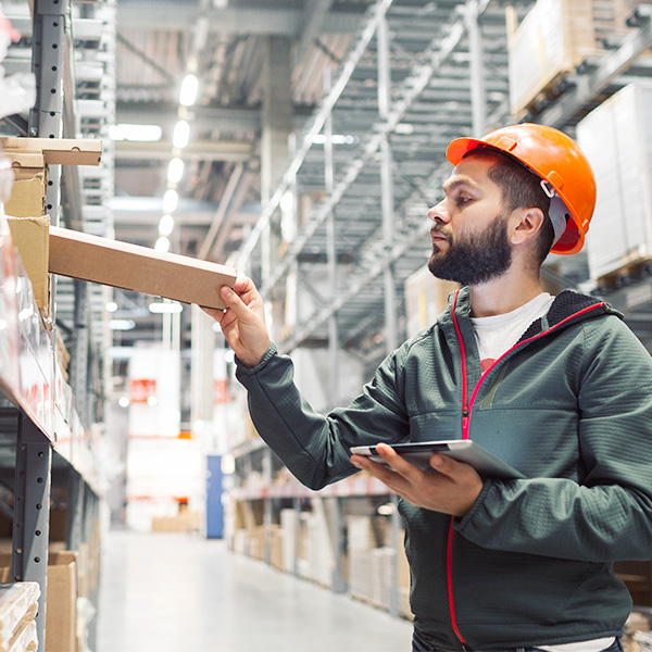 Worker taking inventory of materials in warehouse