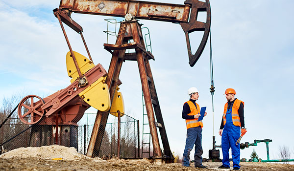 Workers conversing by oil rig