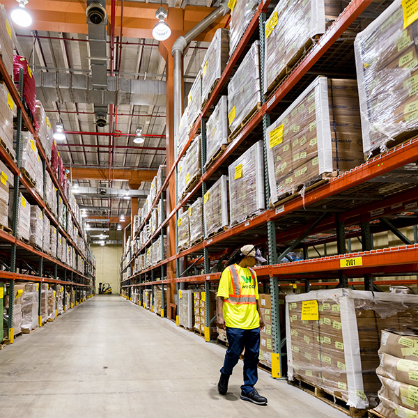 Wesco worker walking through supply warehouse