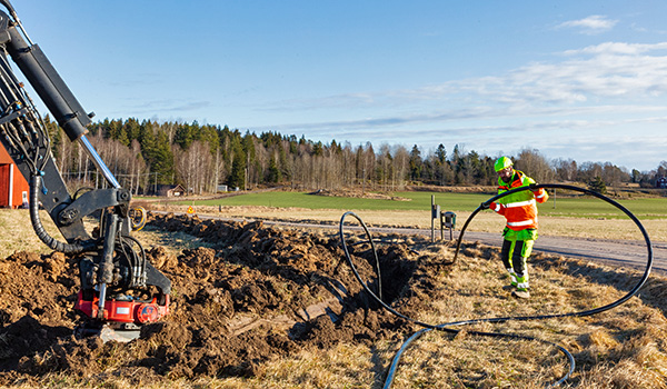 Maintenance engineer installing fiber‑optic cable at a construction site.