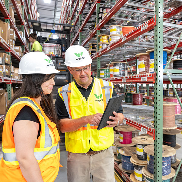 Wesco workers with tablet in inventory aisles