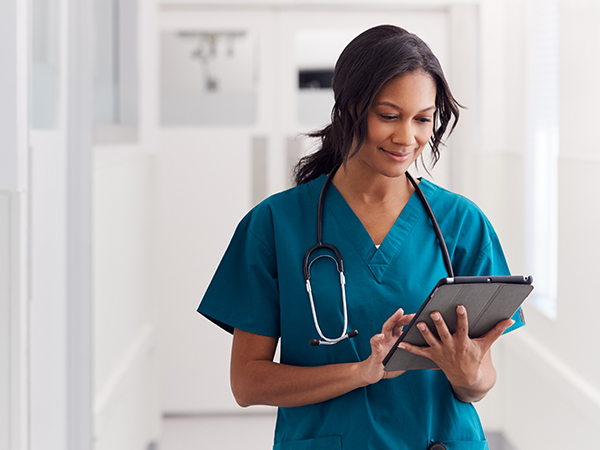 doctor using tablet in hospital hallway