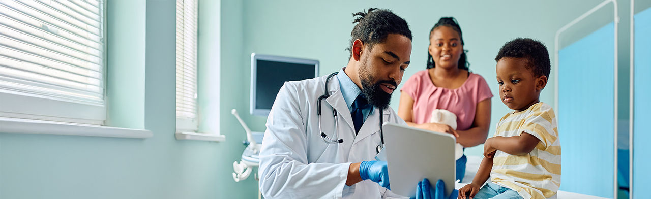 Pediatrician and small boy using touchpad