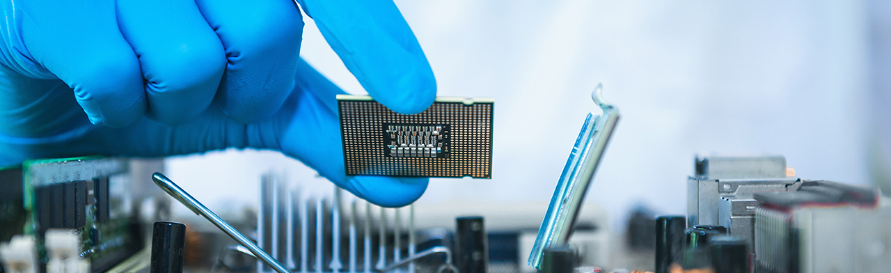Gloved hand holding microchip