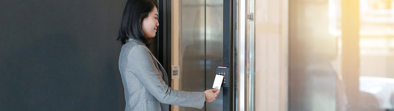 Woman using access control to enter secure building.