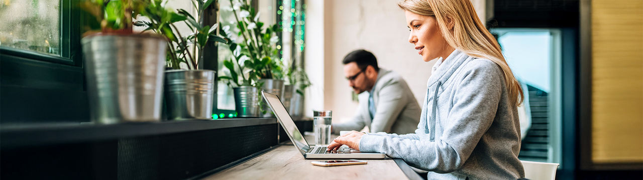 Woman working on laptop in cafe