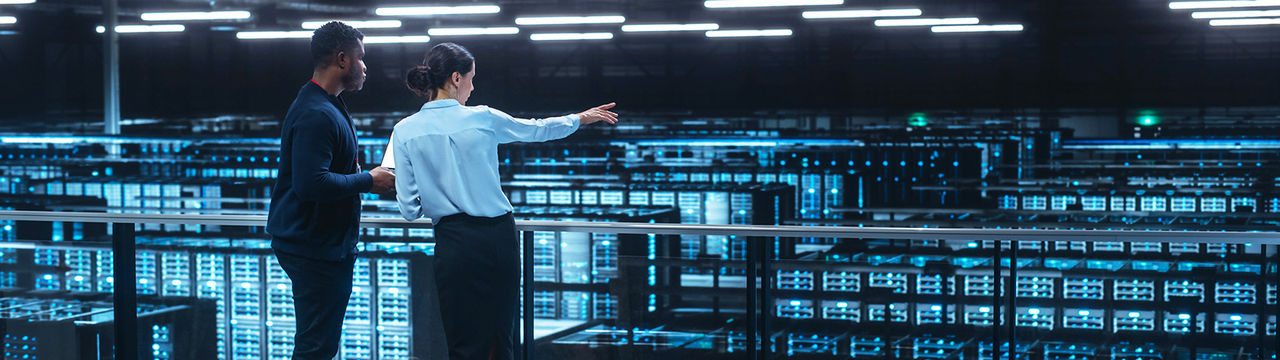 Engineers looking out above large data center