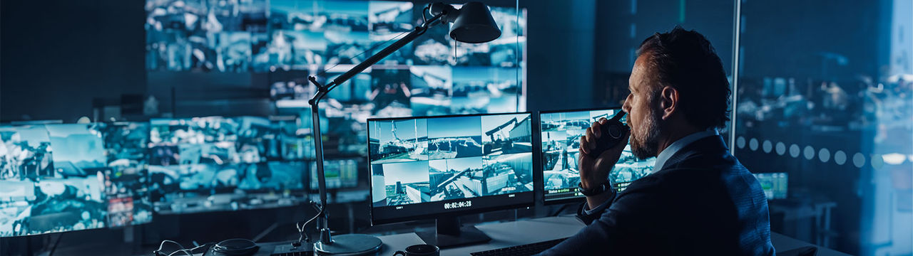 Security surveillance room with guard monitoring cameras.