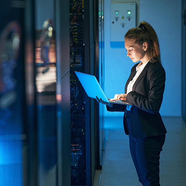 Woman using laptop in data center