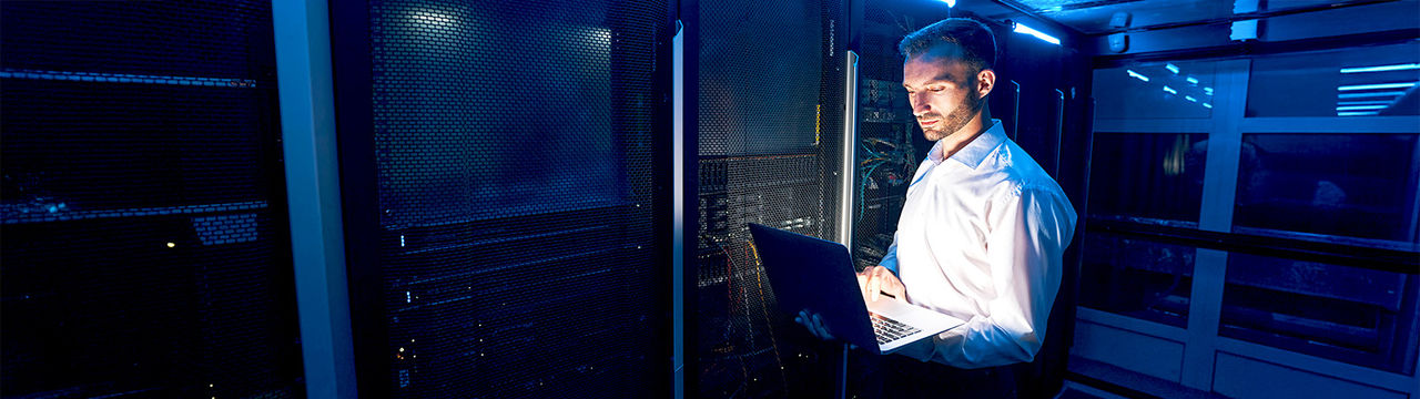 IT manager with laptop in data center