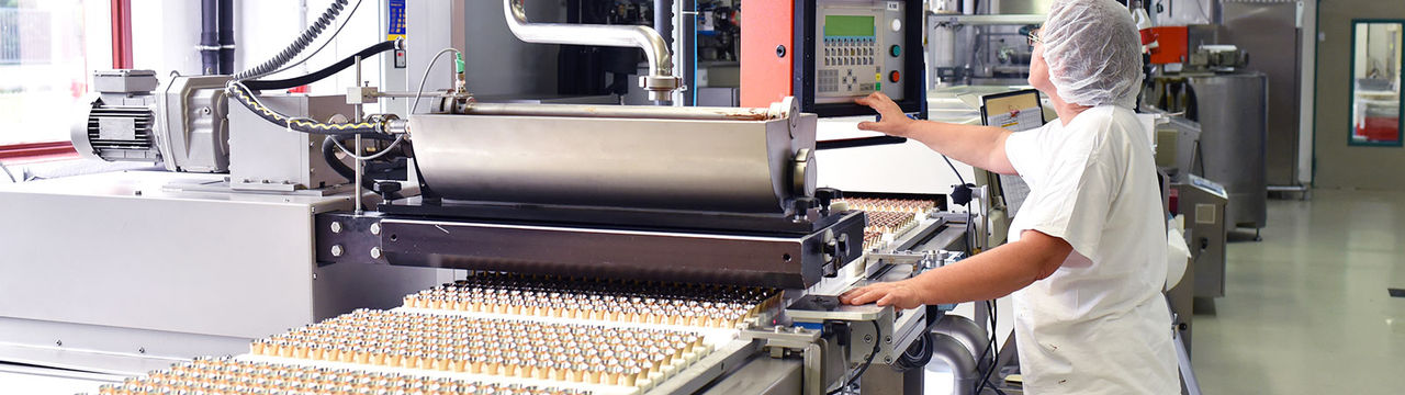 Worker at food production line in modern factory