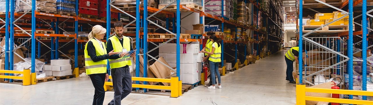 Workers walking through warehouse with clipboard