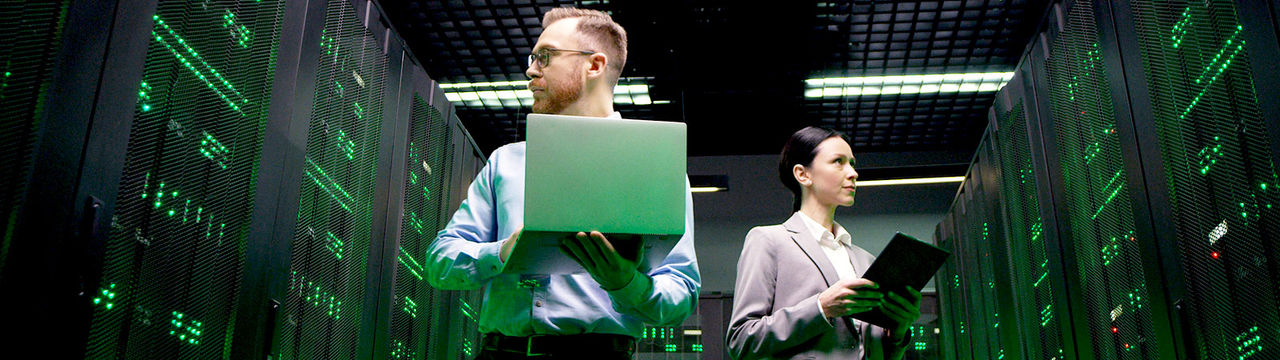 Software engineers with laptops checking servers