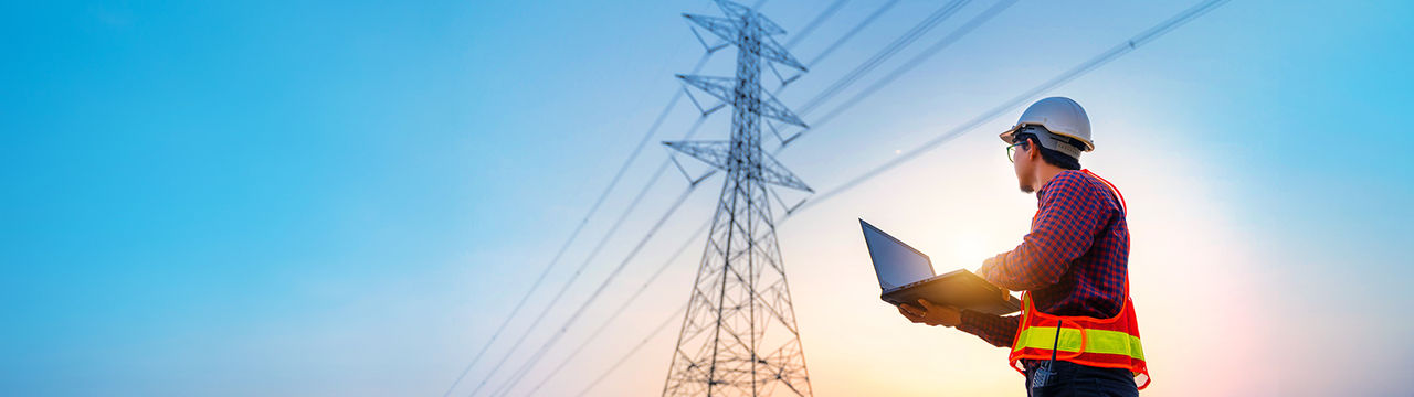Engineer with computer and power lines