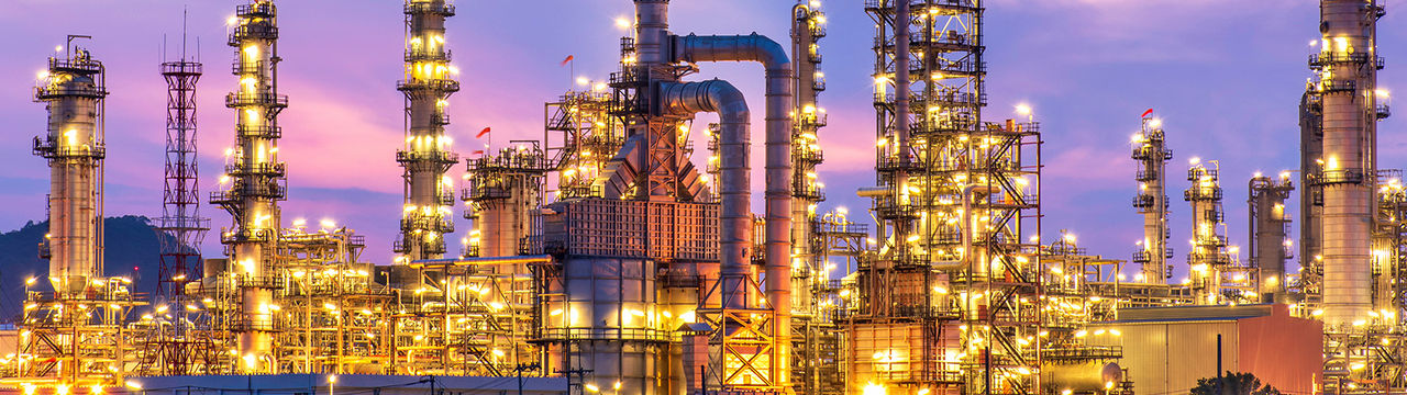 Bright oil refinery at dusk