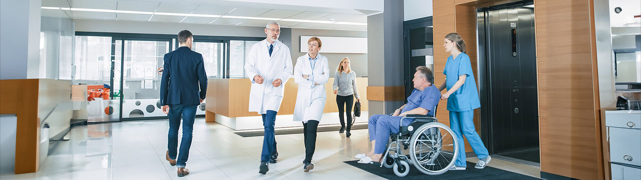 Healthcare hospital facility lobby with doctors and patients.