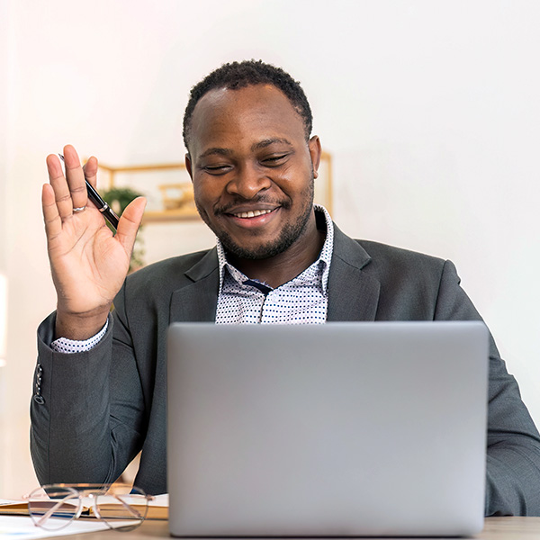 Smiling man waving on virtual meeting