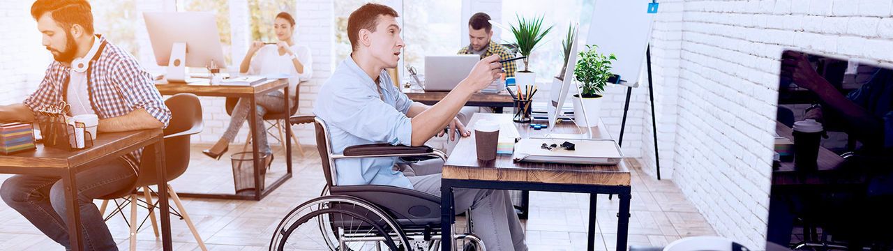 Man in wheelchair working at office computer