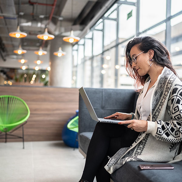 Woman using laptop in modern smart office building