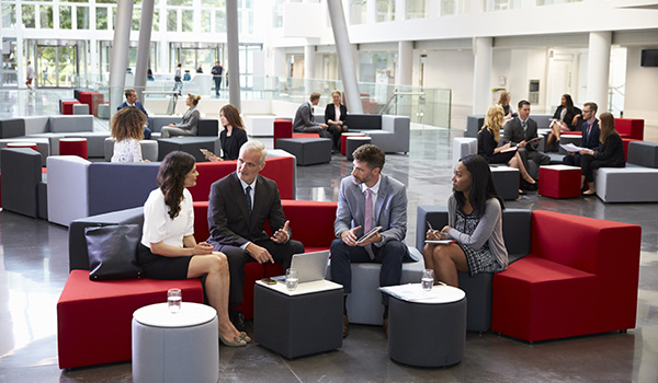 Busy lobby with business people meeting using wireless devices.