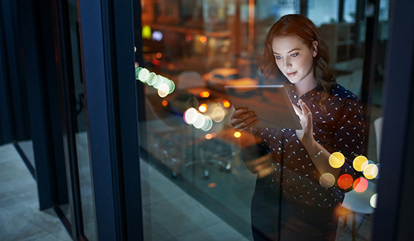 Professional woman using wi-fi device in modern office.