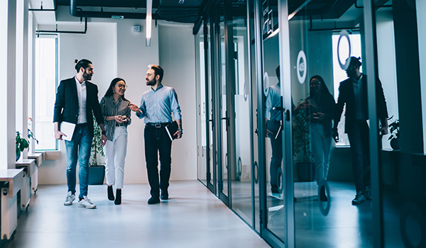 Young professionals walking the hall of a modern office building.