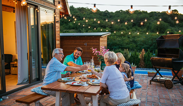 Family during dinner, celebrating together in the backyard.